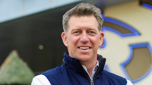 A person stands in front of a blurred out building