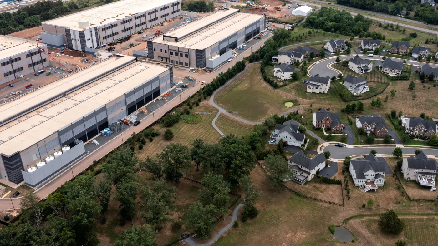 An aerial view of large industrial buildings near homes.