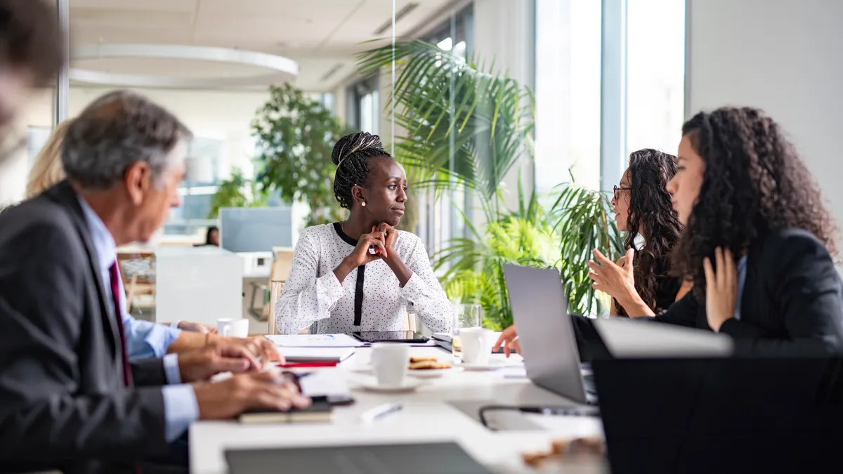 Black CEO listens to colleague during meeting