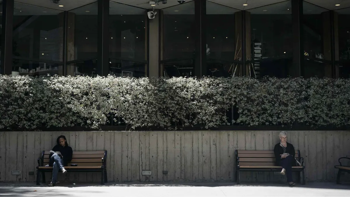 People sitting on two distanced bench