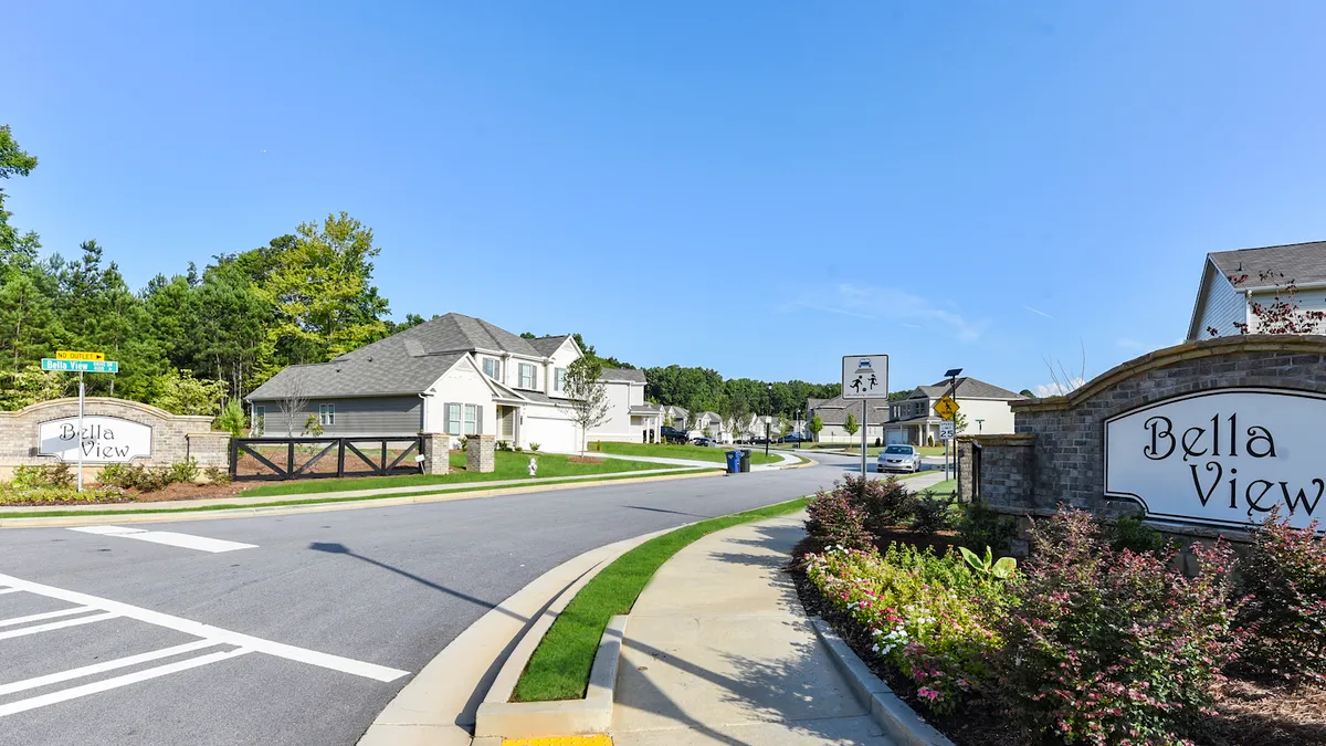 White houses with a street and sign in the foreground