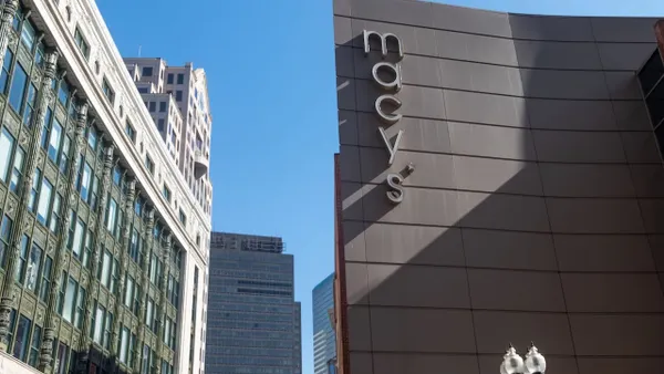 The tops of two city buildings, with blue sky in between.