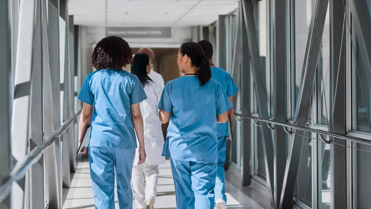 A group of medical professionals walk down the hallway together.