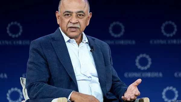 a close up shot of Arvind Krishna in business attire, speaking in a conference setting