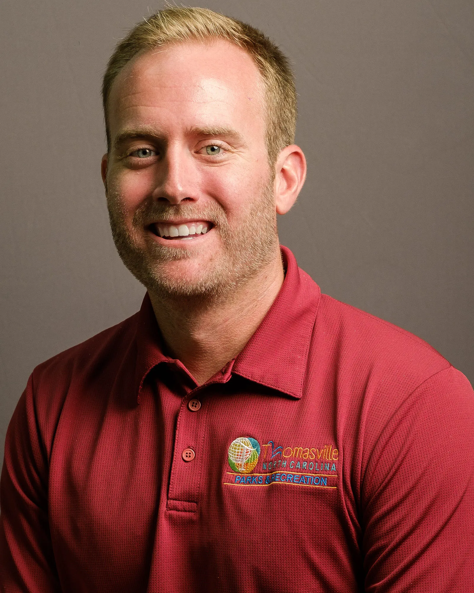 Headshot of a mad wearing a read polo shirt.