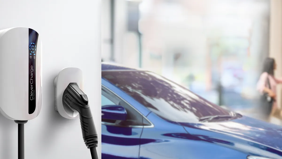 An electric vehicle charger on a wall, next to a car.