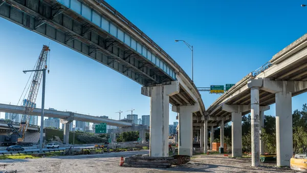 Two highway overpasses curving in different directions are seen from below.