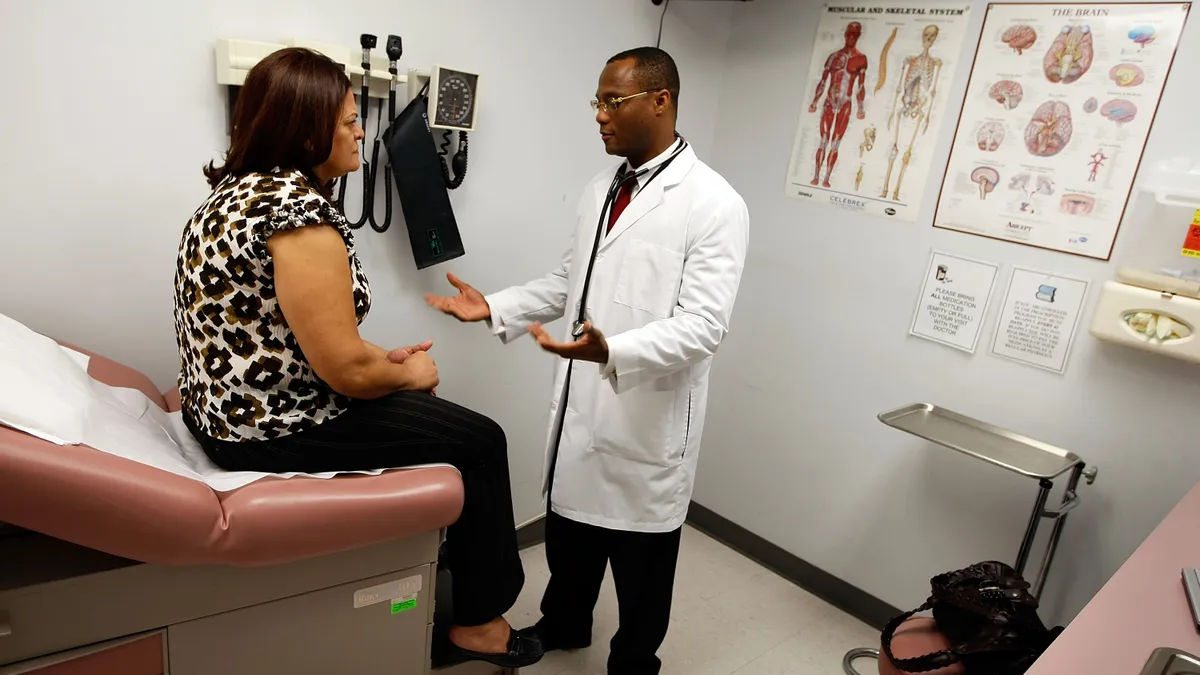 A physician explains things to a patient in an examination room