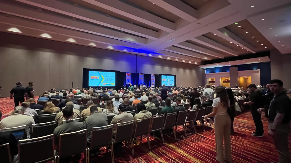 Attendees sit in an auditorium for the opening session of the NFMT East Conference.