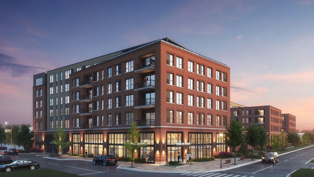 A red brick apartment building surrounded by roads.