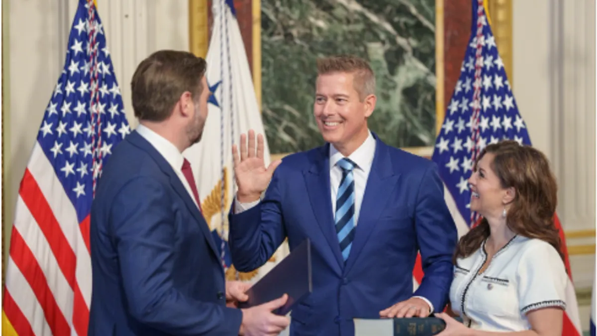 Three people stand by U.S. flags as one raises his hand, the other on a bible.