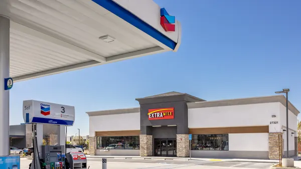 A photo of the exterior of a gas station and convenience store. The sign above the door says ExtraMile.