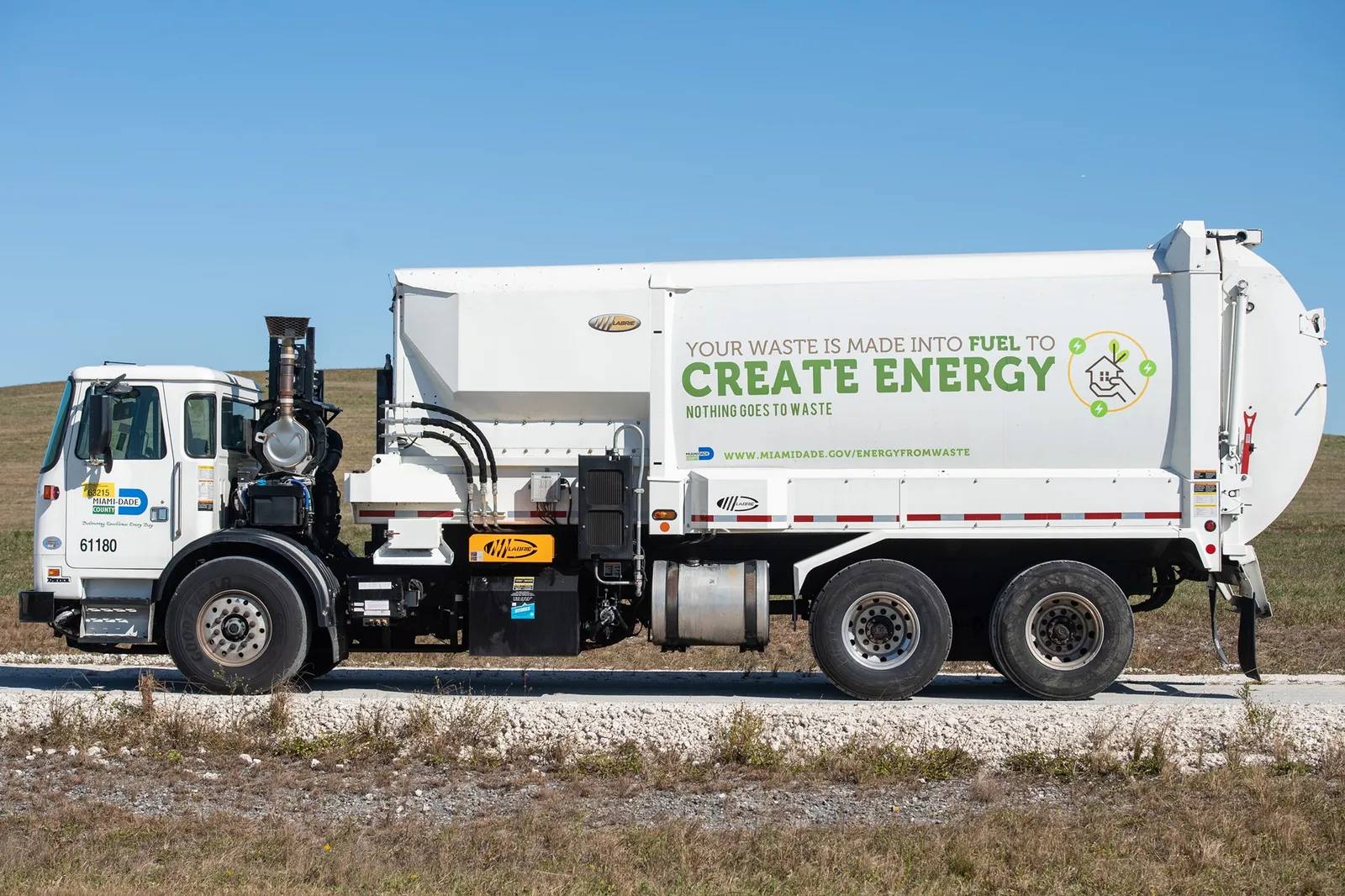 A white waste collection truck in Miami-Dade County, Florida