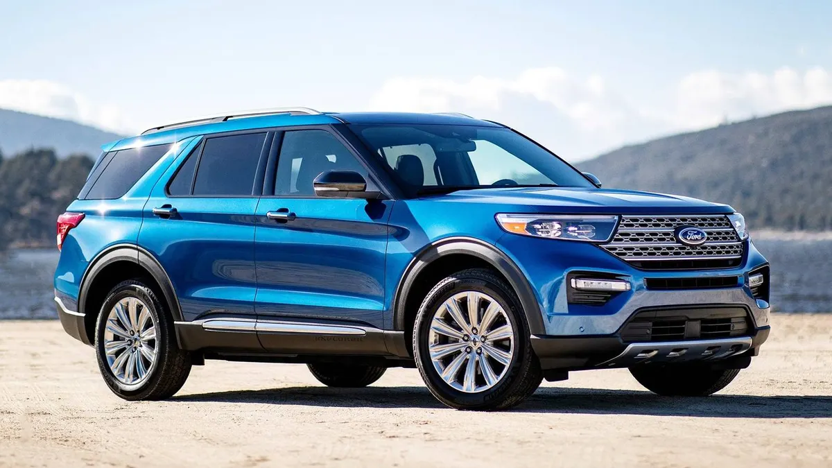 A blue 2021 Ford Explorer SUV parked outdoors with a lake in the background.