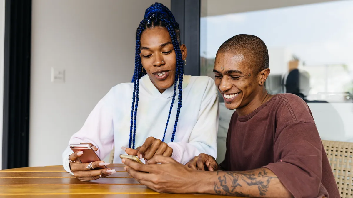 Two Black and brown employees work together in an office