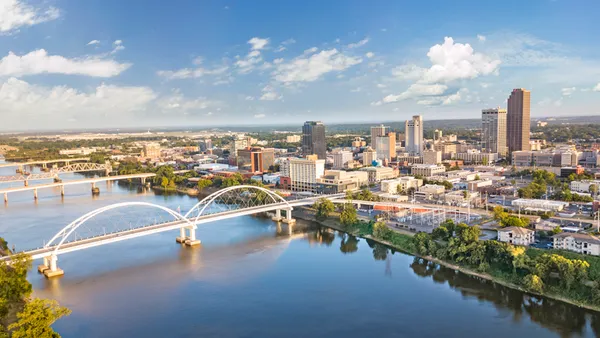 An aerial shot of Little Rock, Arkansas shows a river, bridges and a number of downtown buildings.