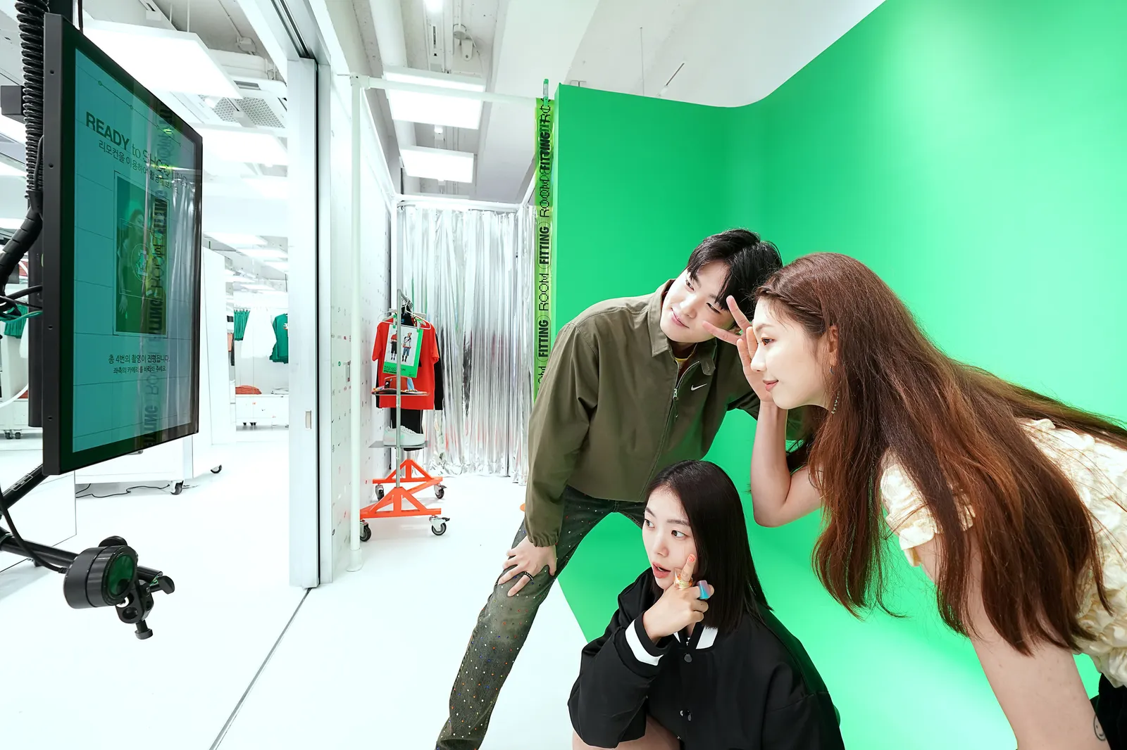 People pose in front of a screen at the content studio in Nike's Nike Style store in Seoul, South Korea.