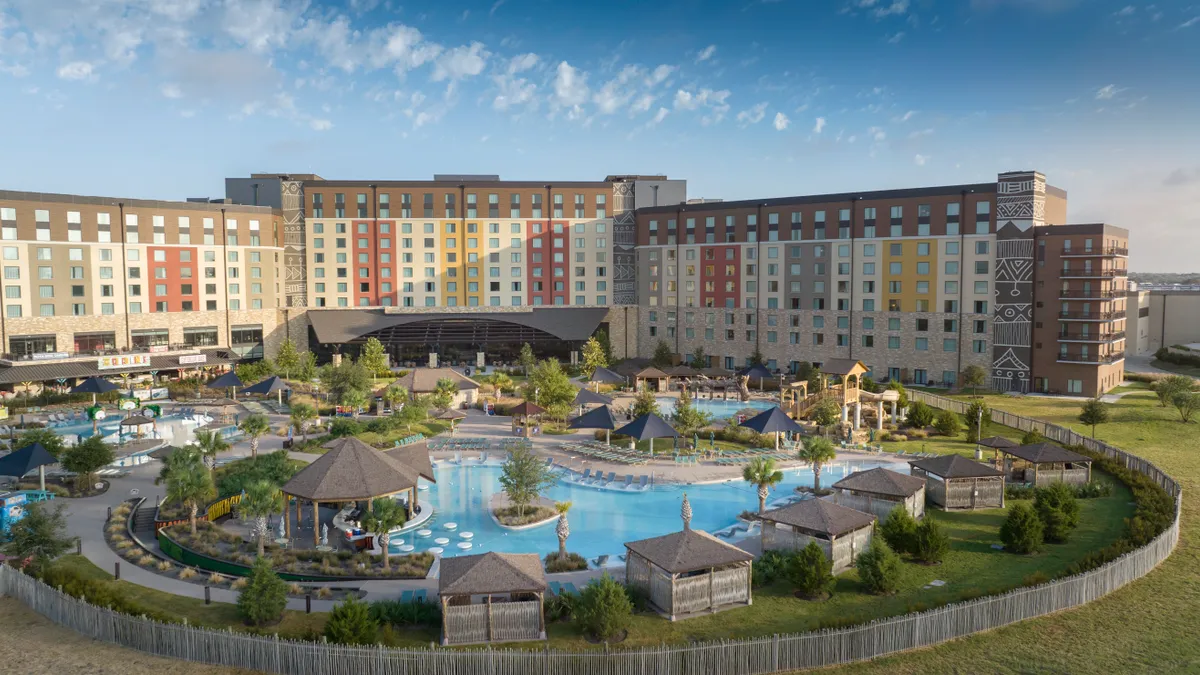 A rendering of a hotel behind a large outdoor pool.