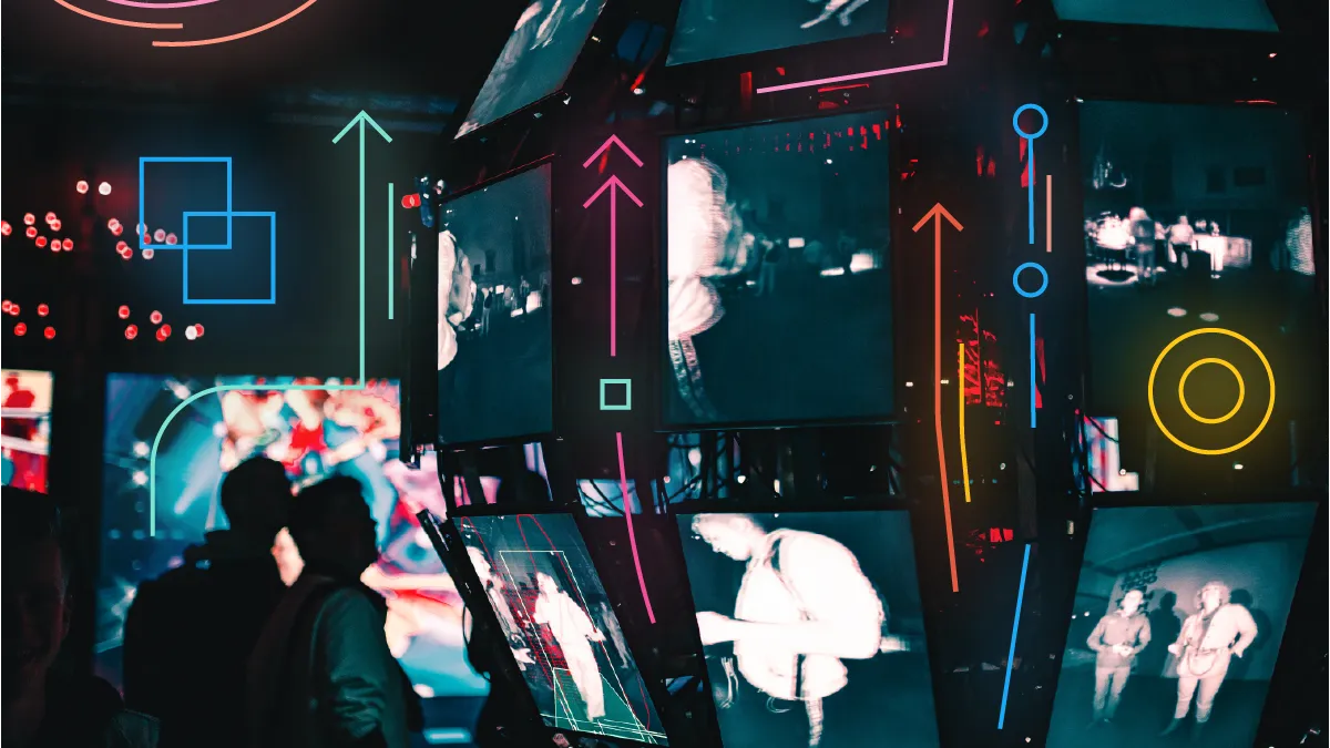 A group of people standing around a display of video screens