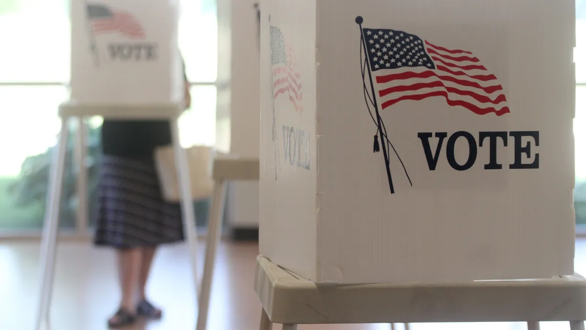 A person cast a ballot in a voting booth.