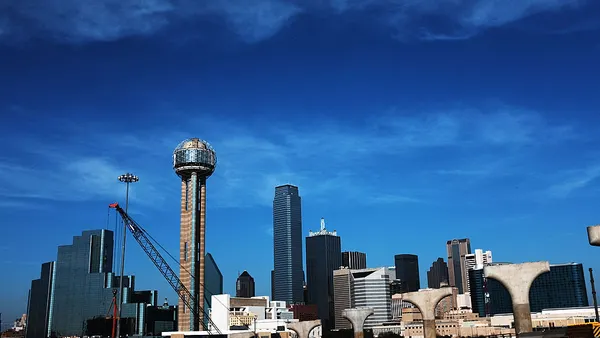 Tall Dallas buildings against a blue sky.