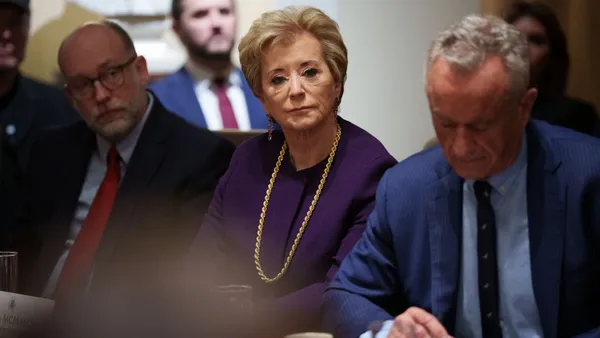 Three people sit at a table.