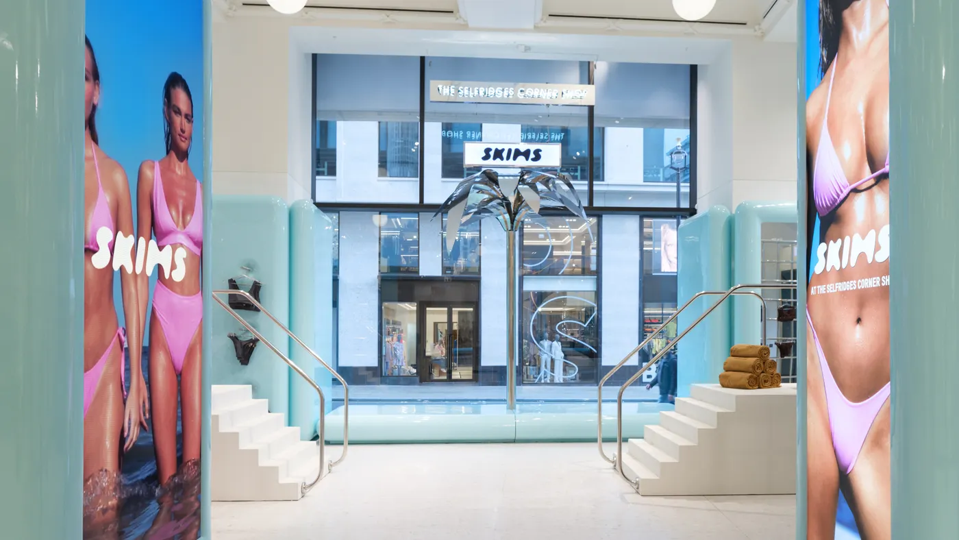 A blue and white Skims pop-up shop in London featuring pink bikini imagery