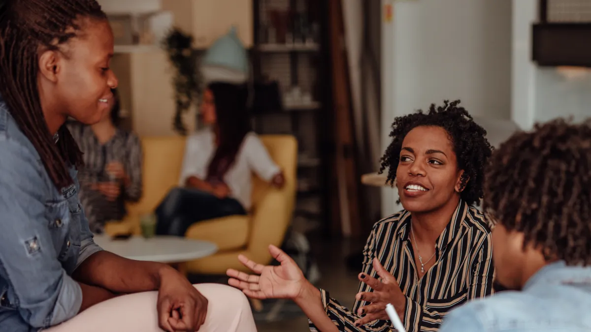 Black employees talking, happy at work.