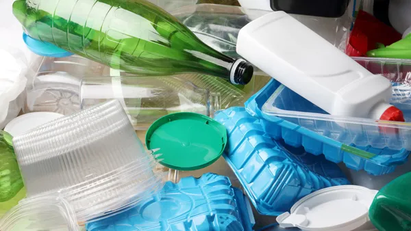 A pile of mixed recyclables of different materials, including bottles and containers