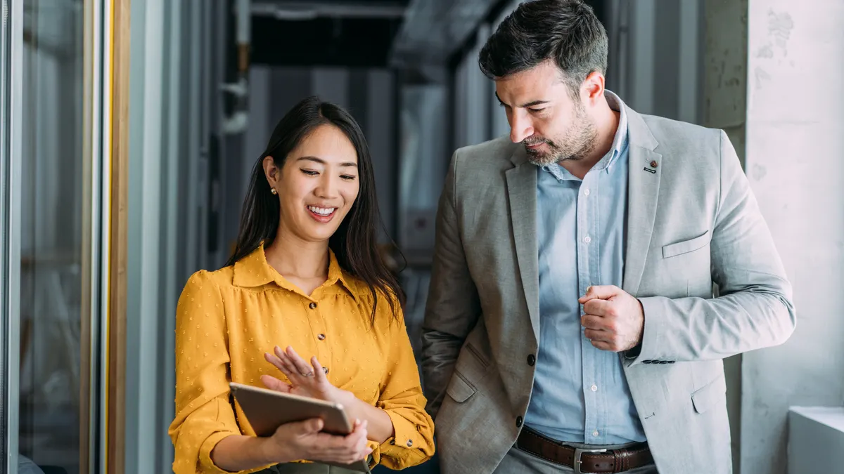 Two confident business persons talking in the work place
