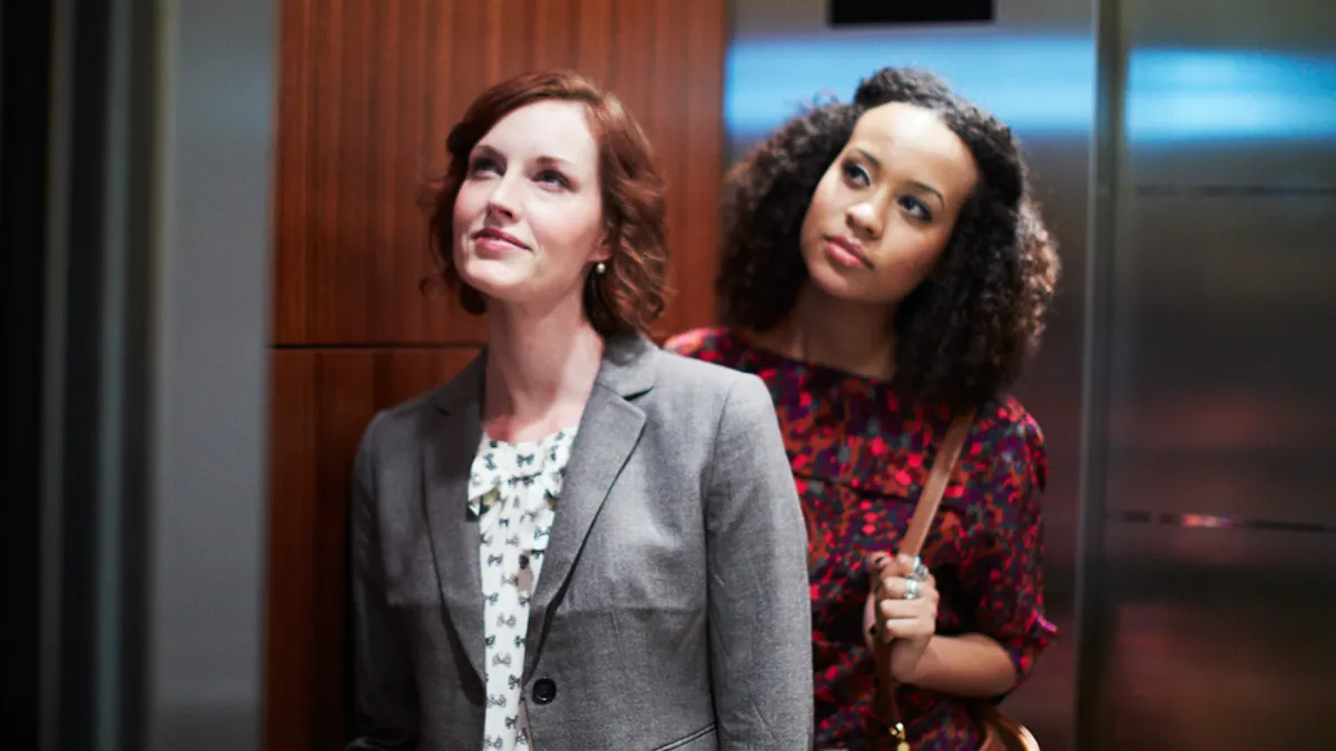 Two women waiting to get off an elevator