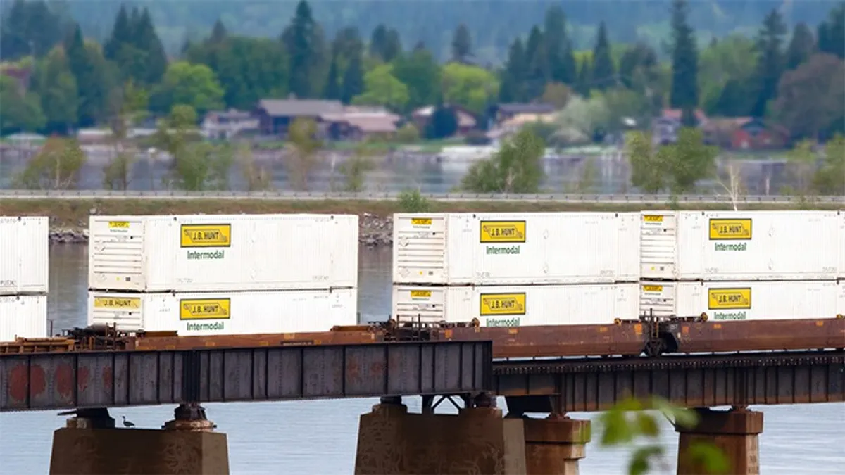 A moving line of rail cargo with J.B. Hunt containers.