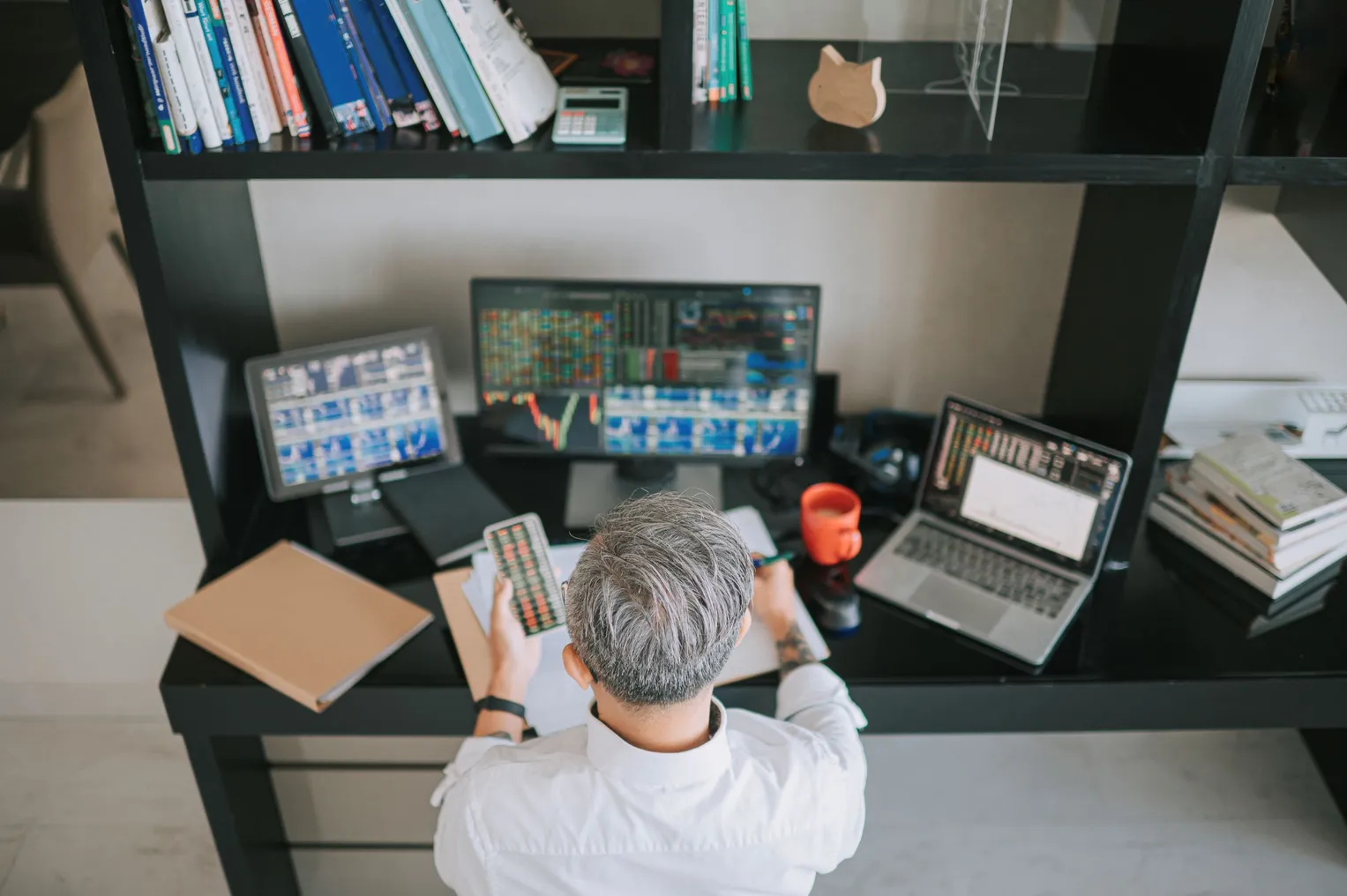 A person sits in front of four screens.