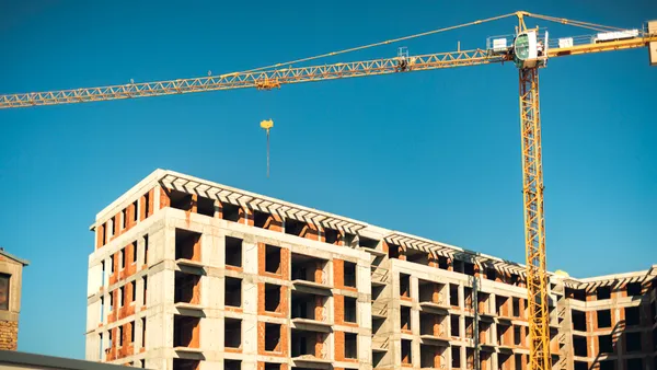 A crane hovers above a hotel construction site.