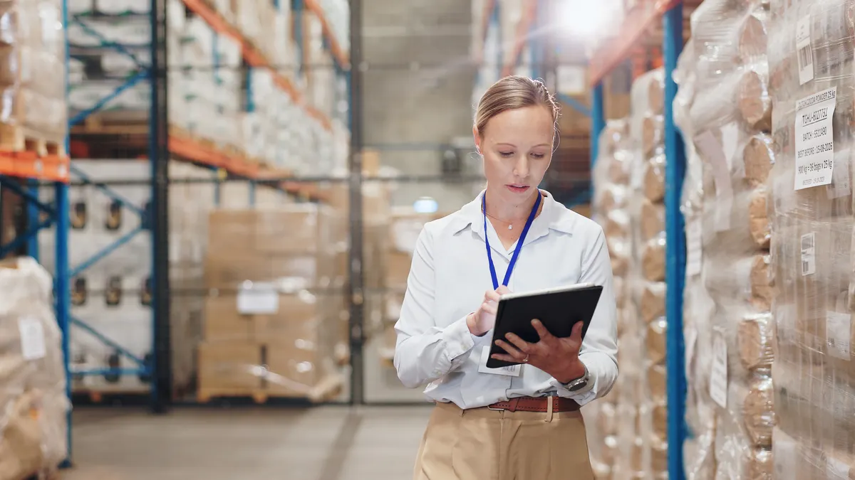 Warehouse check with tablet by business woman