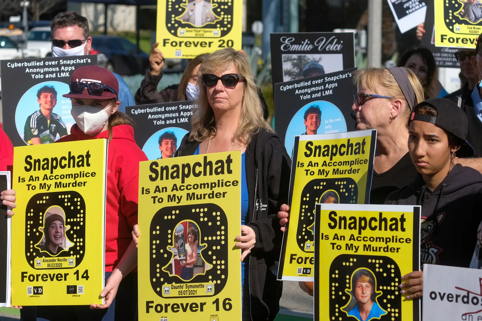 People gather with signs that read "Snapchat Is An Accomplice To My Murder".