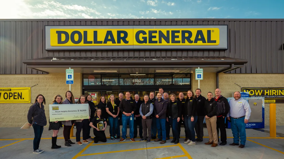 A large crowd of people pose at the front entrance of the 19,000th Dollar General store in Missouri during an opening ceremony.