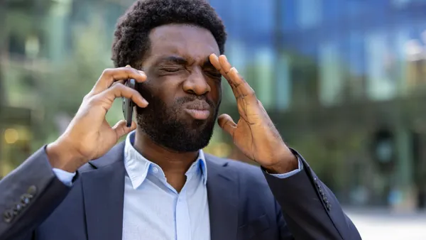 Person frustrated while speaking on the phone
