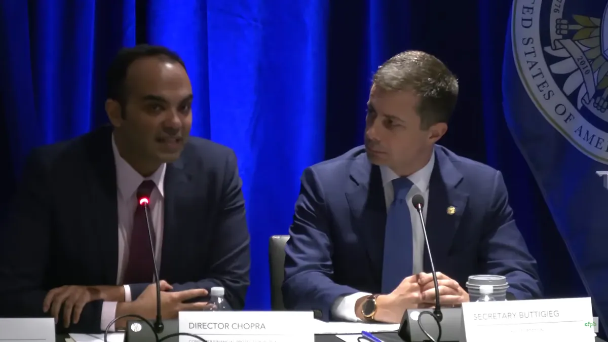 CFPB Director Rohit Chopra sitting on a panel next to Secretary of Transportation Pete Buttigieg.