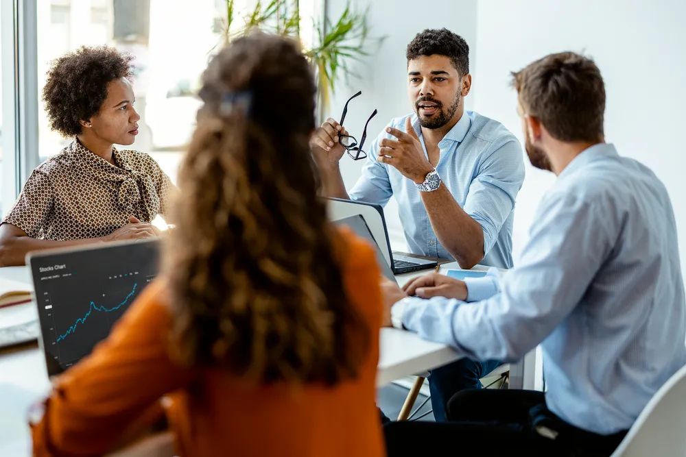 Professionals have a meeting in front of a computer.