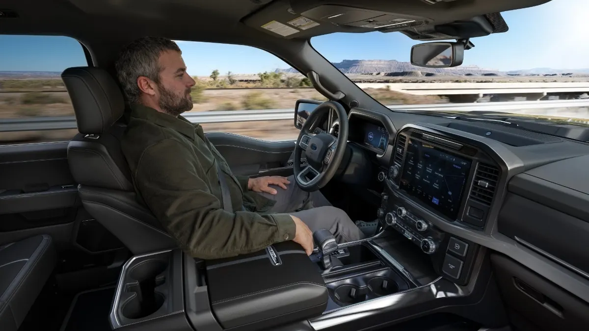 A driver in a Ford SUV travels on a highway without their hands on the steering wheel while using the automaker's BlueCruise automated driving feature.