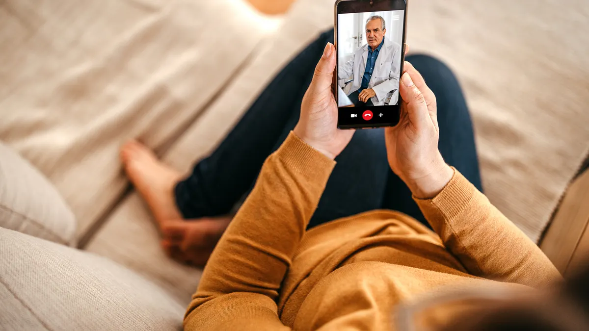 Mature woman having online consultation with doctor at home on smartphone