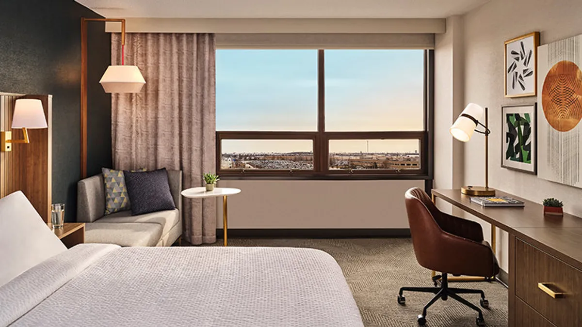 A hotel bed by a window.