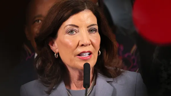 Headshot of a woman speaking into a microphone.