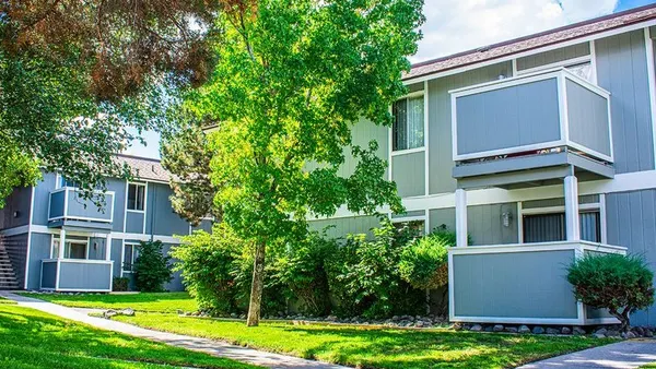Two level apartments with trees in the foreground.