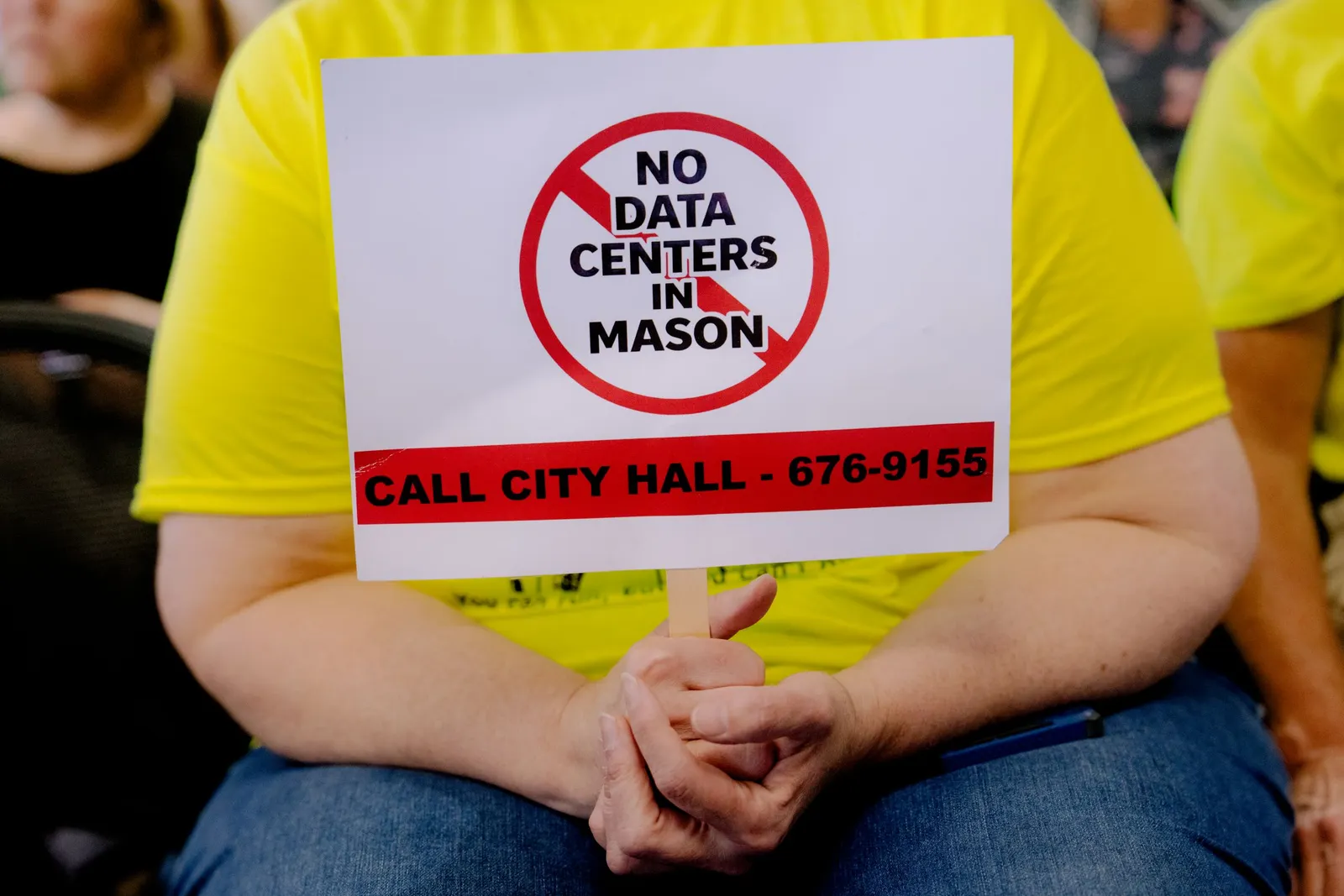 A person holds a sign that says "No data centers in Mason"