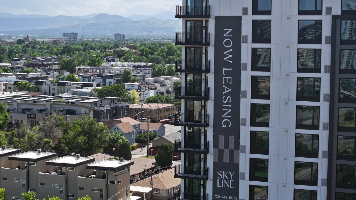 An apartment building set against a city skyline.