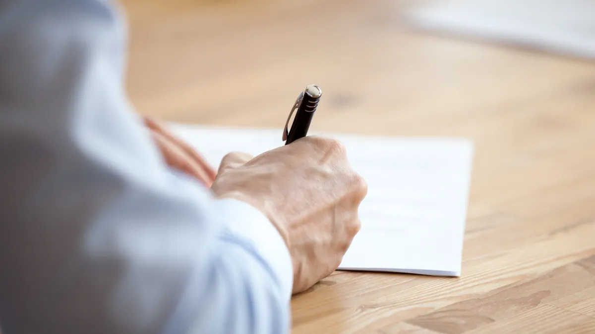 Man hand holding pen, employee, office worker, businessman signing contract at negotiations, trainee, intern writing, taking notes at company meeting, briefing, business training, hands view, close