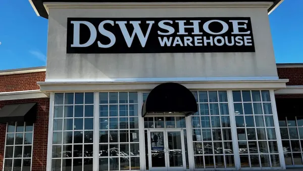 The exterior of a DSW Shoe Warehouse store with a blue sky