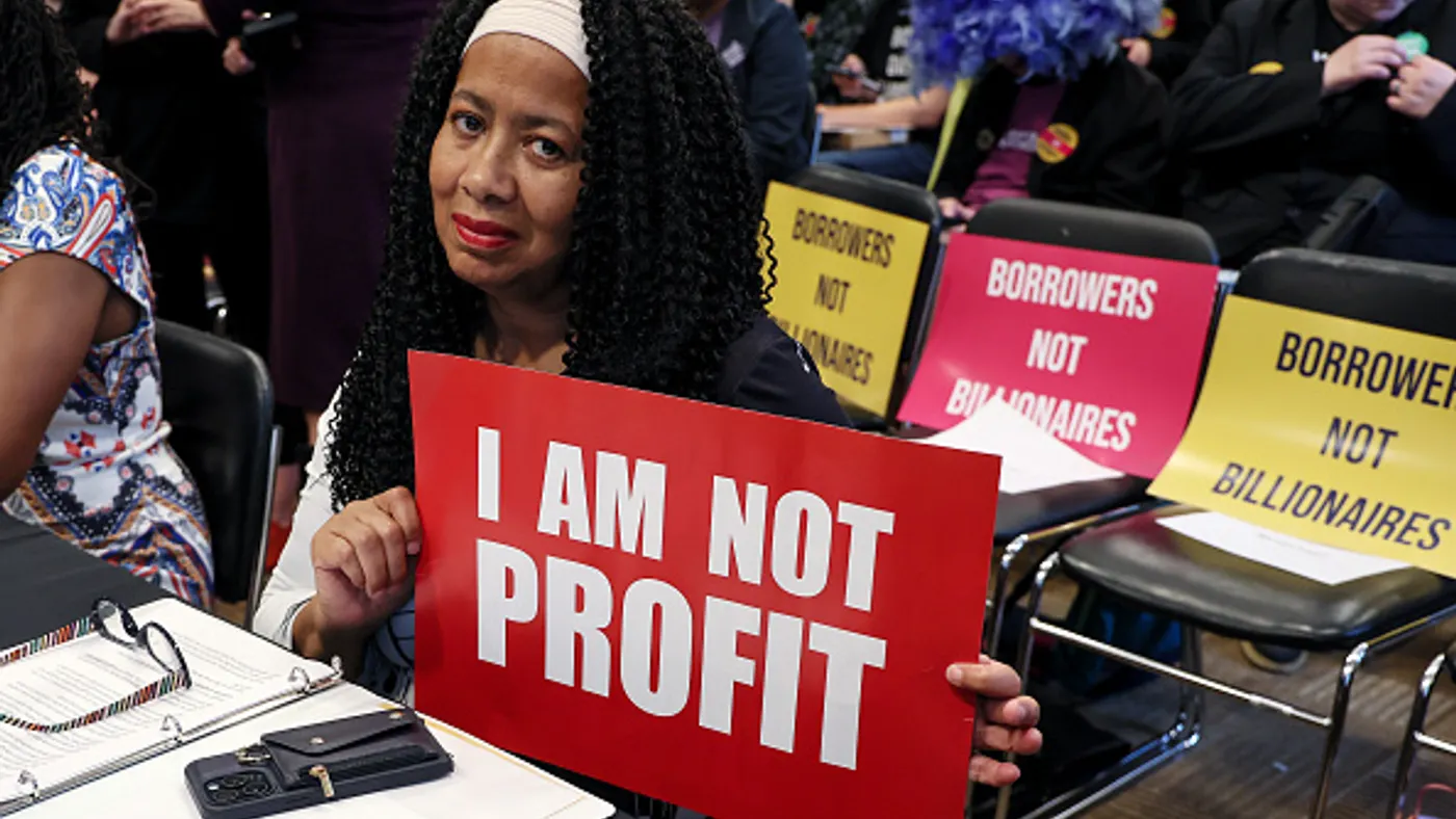 Student loan borrow holds up sign